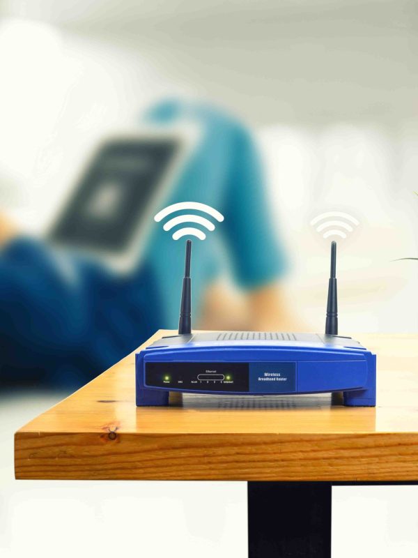 closeup of a wireless router and a man using smartphone on living room at home ofiice